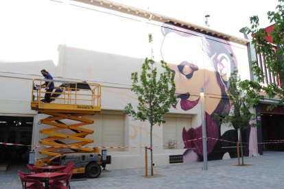 L’artista Sergi Gaya, ahir en plena acció pictòrica del mural en una façana de L’Amistat.