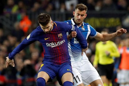 Gerard Piqué protege la pelota ante Leo Baptistao.