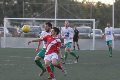 Un jugador de l’Artesa pugna per defensar la possessió de la bimba davant un contrari del Balàfia.