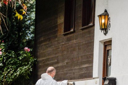 La Policía científica toma fotos de la puerta de la casa.