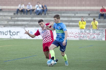 Un jugador del Balaguer i un altre de l’Igualada lluiten per la pilota.