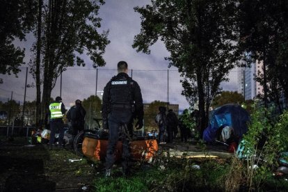 Un gendarme supervisa el desmantelamiento de un campamento de inmigrantes ilegal en París.