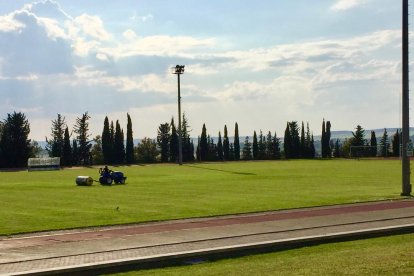 Un tractor trabaja sobre el césped del campo de rugby del Inefc que también se utiliza para fútbol.