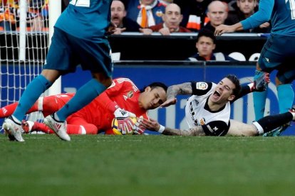 Keylor Navas agafa la pilota davant del davanter del València Santi Mina durant el partit d’ahir.