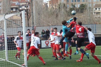 El portero del Linyola, Marcel, uno de los protagonistas del partido de ayer, despeja con el puño ante la presencia del capitán del Tàrrega, Alberto y del también local Bachana.