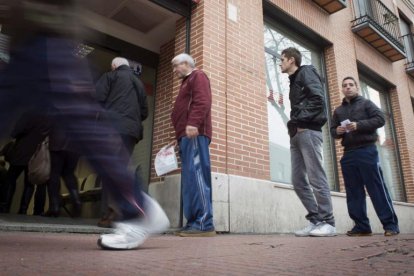 Imatge d’arxiu de parats fent cua a una oficina per registrar-se com a aturats.