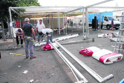 Operarios trabajaron ayer por la mañana, antes de que lloviera, desmontando carpas. 