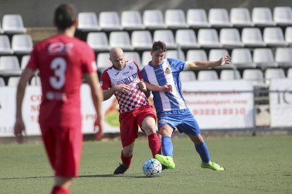 Un jugador del Balaguer pugna per la possessió de la pilota amb un rival.