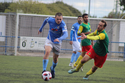 Un jugador del Binèfar supera un rival en una acció del partit.