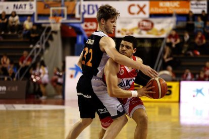 Tim Derksen, que va jugar un gran partit, defensa un jugador del Manresa.