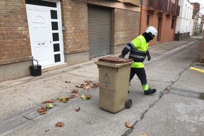 Operarios de la empresa Sorigué haciendo la recogida puerta a puerta ayer en La Granja d’Escarp.