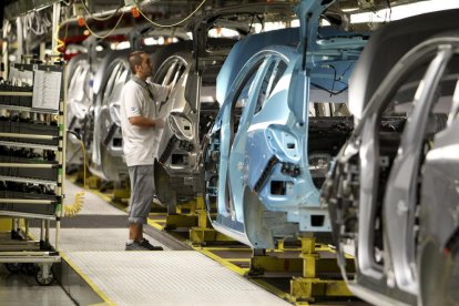 Un operari en una cadena de muntatge en una fàbrica.