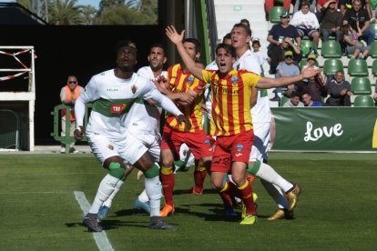 Juanto Ortuño reclama amb un gest obrint els braços entre un núvol de jugadors dels dos equips.