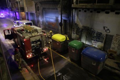 Bomberos sofocando la noche del viernes un incendio que afectó tres contenedores en Lluís Roca. 