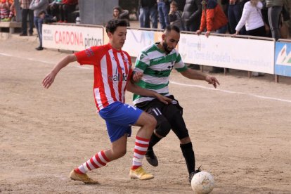 Un jugador del Verdú intenta mantener la posesión del balón ante la presencia de uno del Pobla.