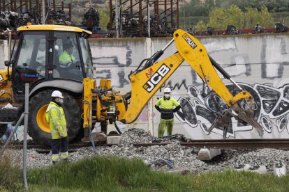 Maquinària pesant i operaris amb mascaretes reparen la línia de Manresa al seu pas per Lleida.