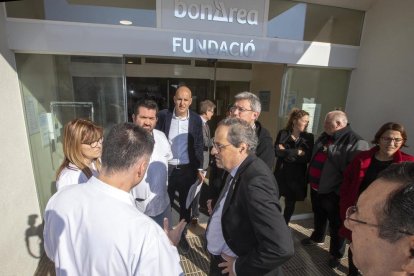 Torra escolta les explicacions de personal sanitari i posa amb l’alcalde de Guissona i aquest grup de joves.