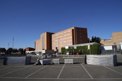 Personal del SEM plegando la carpa que instalaron en junio junto a Urgencias del Arnau y a la derecha, material para vallar la zona donde se construirá el anexo al hospital.