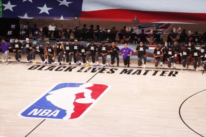 Los jugadores de los Lakers y los Clippers se arrodillan durante el himno nacional de EEUU.