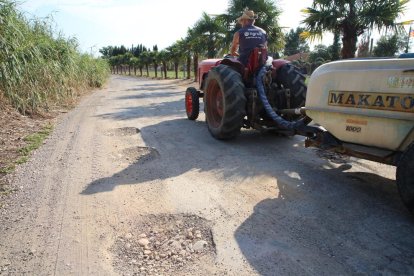 Un tractor en un camino lleno de baches en Vallcalent.