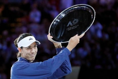 Victoria Jiménez, a la izquierda, con el trofeo de campeona. A la derecha, Muguruza tras perder la final.