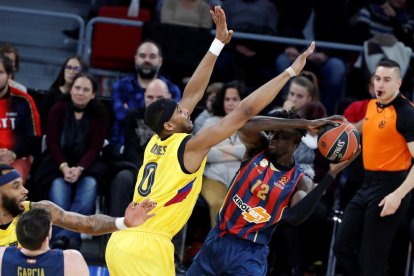 El barcelonista Davies intenta impedir el pase de Diop.