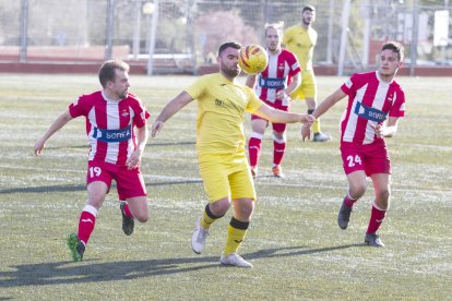 Ciru intenta mantener la posesión del balón ante la presión de dos jugadores del Valls.