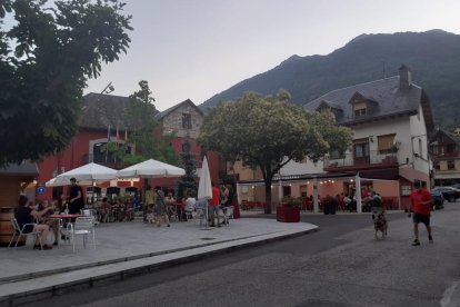 Persones passejant i consumint a les terrasses de bars de Les, que habitualment rep nombrosos veïns de França.