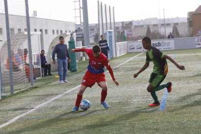 Un jugador del Torrefarrera porta la pilota davant de la vigilància d’un defensor del Cervera.