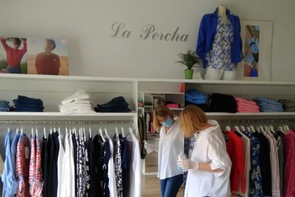 La responsable de la tienda ‘La percha’ limpia a conciencia los cristales con gel. 