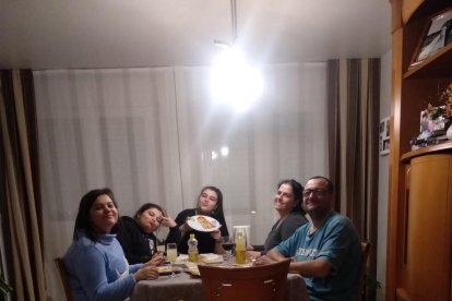 Cena familiar. Arriba, cumpleaños confinado. A la derecha, una de las hermanas tiende la ropa tras repartirse las tareas domésticas.