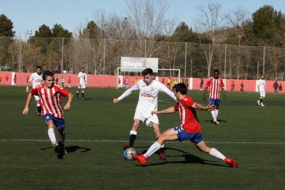 Un jugador del Borges intenta superar dos rivals en un moment del duel.