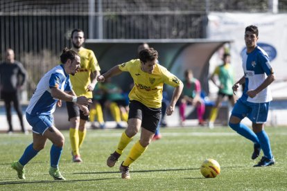 Un jugador del Mollerussa supera un membre rival en una acció del partit.