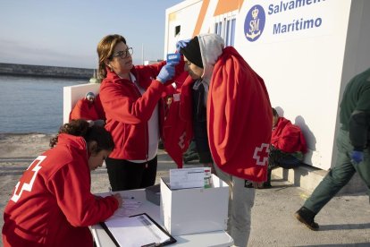 Personal de Creu Roja pren la temperatura a una migrant.