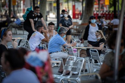 Diverses persones gaudeixen de l’obertura de terrasses a Barcelona.