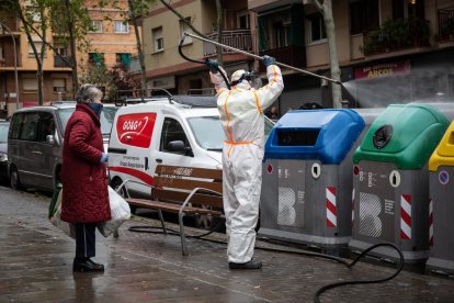 Un operari desinfecta un cubell d’escombraries a Barcelona.