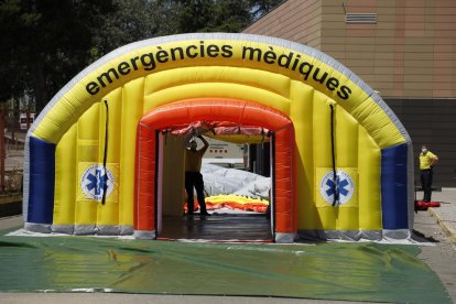 A l’esquerra, tasques de muntatge de la carpa. A la dreta, professionals del SEM al costat de la delegada de Salut, Divina Farreny.