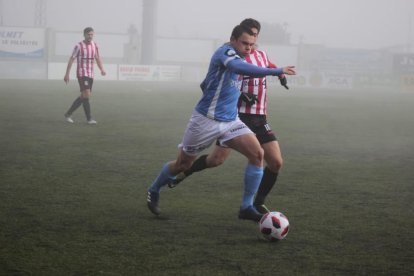 Un jugador del Binéfar disputa el balón con un rival durante el partido.