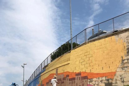 L’artista local durant la creació del mural a Menàrguens.