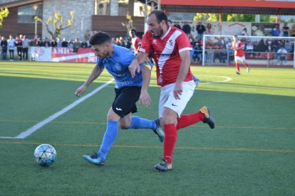 Un jugador del Alcarràs conduce el balón ante la presión de un rival.