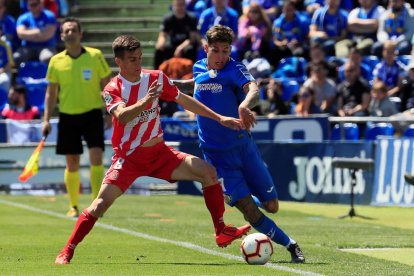 El centrecampista del Girona Pere Pons intenta prendre la pilota a Olivera.