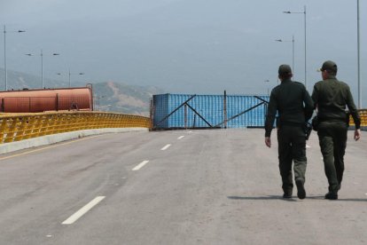 Militars vigilen el pont amb grans remolcs com a barricada.