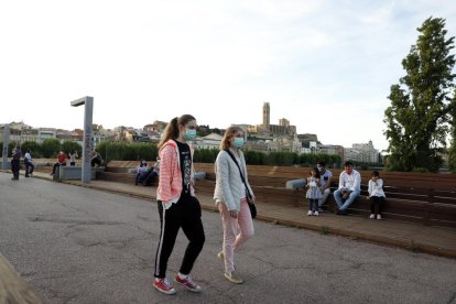 Dos dones passegen per la passarel·la del Liceu Escolar amb mascareta.