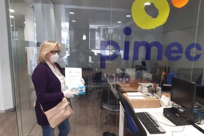 La responsable d’una empresa recull les mascaretes de Pimec.