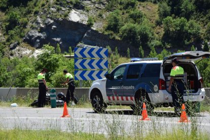 Agentes de los Mossos junto a la moto accidentada ayer en la N-260 en El Pont de Bar. 