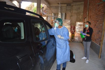 Professionals sanitaris recollint les mostres de les proves que detecten la covid-19 d'un pacient que les porta sense baixar del seu cotxe, en un espai adjacent a l'hospital andorrà.