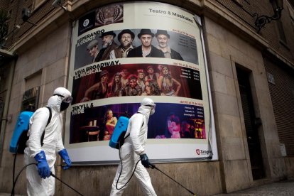 Operaris realitzen tasques de desinfecció als afores d’un teatre a Saragossa.