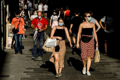 Vianants protegits amb mascaretes en un carrer de Barcelona.