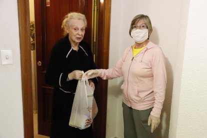 Abella entrega un menú diario a una vecina del edificio El Balcó de Lleida, en la calle Doctor Combelles, ayer. 