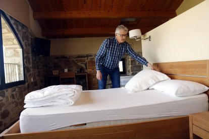 El presidente de la Federación de Casas Rurales de Lleida, Jaume Ramon, arreglando una cama de la casa rural La Torre del Codina, al Talladell.